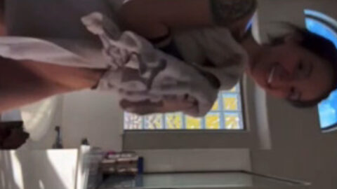 Cute girl in towel experiencing accidental flash leaving the bathroom